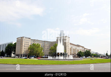 Eine kreisförmige Brunnen am Strausberger Platz auf Karl Marx Allee in Ost-Berlin mit einer kommunistischen Ära Gebäude im Hintergrund Stockfoto