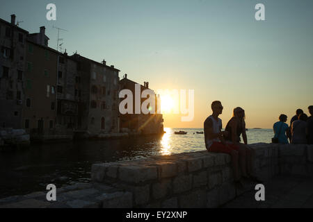 Menschen an der Küste vor dem alten Gebäude der Stadt Kern sitzen und den Sonnenuntergang in Rovinj, Kroatien. Stockfoto