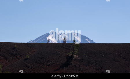 Vater und zwei Kinder wandern entlang des Randes des Stockfoto