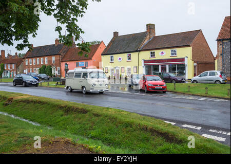 Sahnen Sie Volkswagen T2 Wohnmobil fahren durch das Dorf von Burnham Ländermarkt in Norfolk, England. Stockfoto