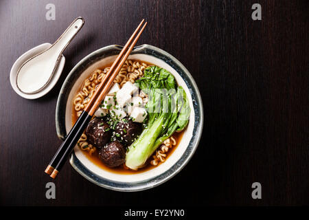 Miso Ramen asiatische Nudeln mit Shiitake, Tofu und Pak Choi Kohl in Schüssel auf schwarzen Tabellenhintergrund Stockfoto