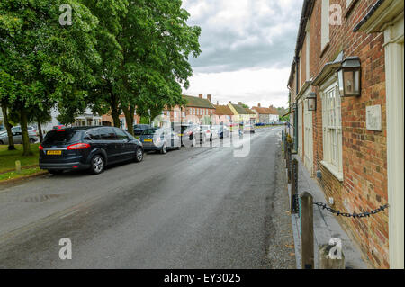 Hauptstraße durch Burnham Market, Norfolk, England an einem nassen Sommertag. Stockfoto