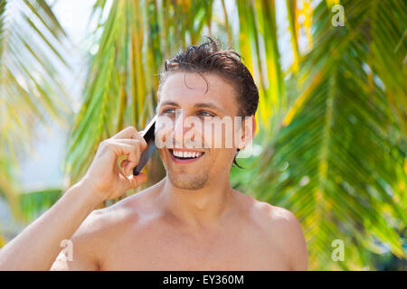 Mann Handy-Anruf Lächeln auf Sommer-Urlaub am Strand Stockfoto