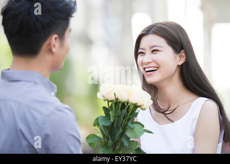 Junger Mann, Blumen, Freundin Stockfoto