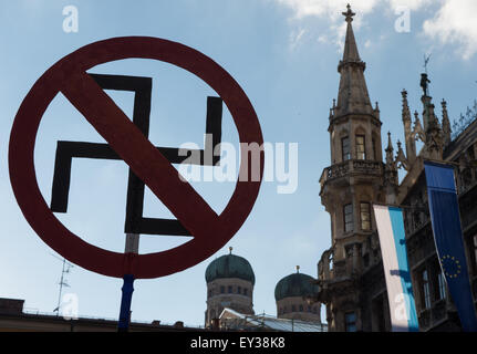 München, Deutschland. 20. Juli 2015. KostenzählerProtestierendern gegen die Anti-islamische Pegida-Demonstration halten einen durchgestrichenen Hakenkreuz in München, Deutschland, 20. Juli 2015. Foto: Peter Kneffel/Dpa/Alamy Live News Stockfoto