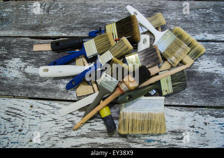 Haufen von verwendeten Pinsel an einer alten hölzernen Oberfläche Stockfoto