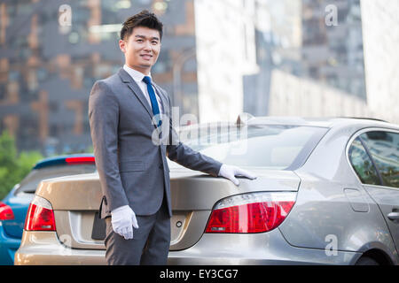 Chauffeur steht neben dem Auto Stockfoto