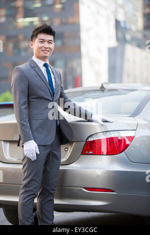 Chauffeur steht neben dem Auto Stockfoto