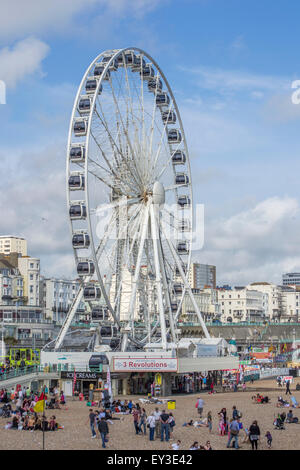 Brighton, Großbritannien - 28. 2014. Juni: Menschen am Brighton Beach rund um das Brighton Wheel, ein Riesenrad, das bis zum 2016. Mai in Betrieb war. Stockfoto