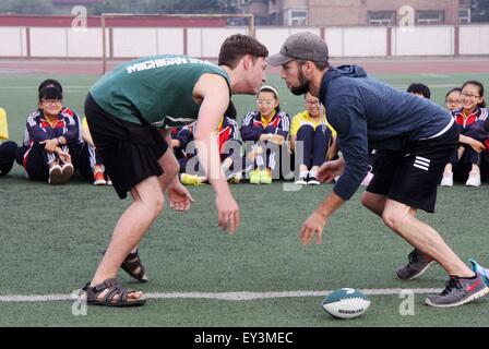 Zhangjiakou, Chinas Provinz Hebei. 21. Juli 2015. Eric (R) und Michael (L), Studenten der Michigan State University, zeigen, dass Fußball mit Xuanhua Nr. 4-Mittelschule in Zhangjiakou, Nordchinas Provinz Hebei, 21. Juli 2015 bewegt. © Chen Xiaodong/Xinhua/Alamy Live-Nachrichten Stockfoto