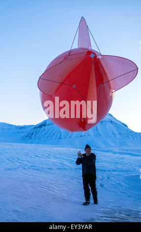 Ein Techniker der atmosphärischen Sternwarte von der Forschungsstation AWIPEV bereitet einen Messung Flug mit einem Fesselballon in der Polarnacht in Ny-Alesund auf Spitzbergen, Norwegen, 9. April 2015. Seit 2003 arbeiten deutsche und französische Forscher in der Forschungsstation AWIPEV in den ehemaligen Bergmann-Siedlungen auf der Inselgruppe Svalbard. Wissenschaftliche Arbeitsgebiete der Koldewey-Station sind die Beobachtung der arktischen Stratosphäre und Untersuchungen des Lebens in und rund um das arktische Meer von Ozeanographen, Ozean Geologen und arktischen Physik. Foto: Jens Büttner Stockfoto