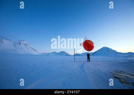 Ein Techniker der atmosphärischen Sternwarte von der Forschungsstation AWIPEV bereitet einen Messung Flug mit einem Fesselballon in der Polarnacht in Ny-Alesund auf Spitzbergen, Norwegen, 9. April 2015. Seit 2003 arbeiten deutsche und französische Forscher in der Forschungsstation AWIPEV in den ehemaligen Bergmann-Siedlungen auf der Inselgruppe Svalbard. Wissenschaftliche Arbeitsgebiete der Koldewey-Station sind die Beobachtung der arktischen Stratosphäre und Untersuchungen des Lebens in und rund um das arktische Meer von Ozeanographen, Ozean Geologen und arktischen Physik. Foto: Jens Büttner Stockfoto