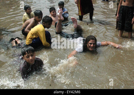 Lahore. 21. Juli 2015. Menschen in Pakistan spielen in einer überfluteten Straße nach schweren Monsun-Regen in östlichen Pakistan Lahore, am 21. Juli 2015. Starker Regen in den verschiedenen Teilen von Pakistan gestört Flug- und Zugverbindungen, berichteten lokale Medien. Bildnachweis: Sajjad/Xinhua/Alamy Live-Nachrichten Stockfoto