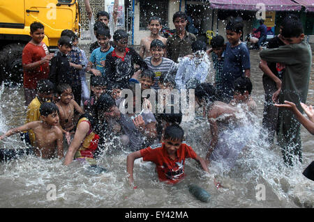 Lahore. 21. Juli 2015. Menschen in Pakistan spielen in einer überfluteten Straße nach schweren Monsun-Regen in östlichen Pakistan Lahore, am 21. Juli 2015. Starker Regen in den verschiedenen Teilen von Pakistan gestört Flug- und Zugverbindungen, berichteten lokale Medien. Bildnachweis: Sajjad/Xinhua/Alamy Live-Nachrichten Stockfoto