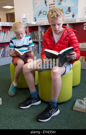 Yong-jungen und Mädchen in der Kinderabteilung der öffentlichen Bibliothek lesen Stockfoto