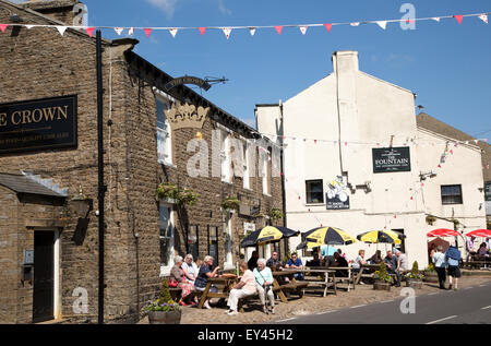 Leute sitzen außen Kneipen im Dorf Hawes, Yorkshire Dales National Park, England, UK Stockfoto