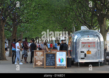 Eines geschäftigen, Sommers Abend auf Londons beliebten Südufer mit Menschen Flanieren entlang der Flussufer Allee von Bäumen, England, UK Stockfoto