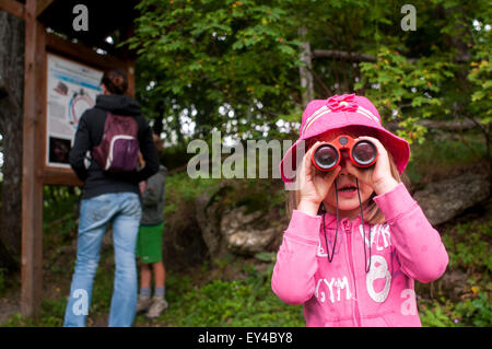 Junges Mädchen Blick durch ein Fernglas, während Frau und junge, schauen Sie sich die Wanderkarte Stockfoto