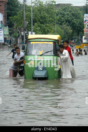 Lahore. 21. Juli 2015. Menschen drücken eine Autorikscha in einer überfluteten Straße nach schweren Monsun-Regen in östlichen Pakistan Lahore 21. Juli 2015. Sturzfluten durch Wolkenbruch ausgelöst haben mehrere Teile von Pakistan von Chitral Tal im Norden des Landes auf Teile des südlichen Punjab und den Bergregionen von Balochistan überschwemmt. Bildnachweis: Sajjad/Xinhua/Alamy Live-Nachrichten Stockfoto