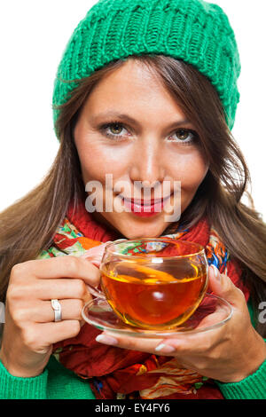 Ziemlich junge Frau tragen grün und rot Wintermode, hält eine Tasse von Kaffee während lächelnd in die Kamera hautnah. Isoliert Stockfoto