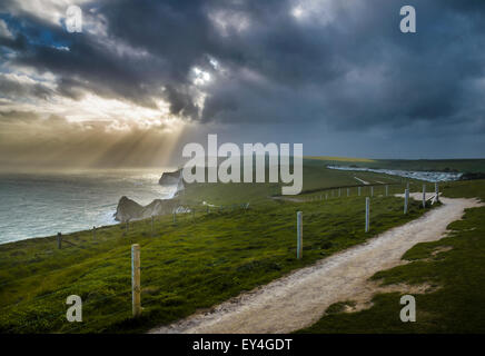 Strahlen der Sonne durch die Wolken guckt und Aufleuchten der Jurassic Coast, Lulworth, Dorset, Südengland, England, Vereinigtes Königreich Stockfoto