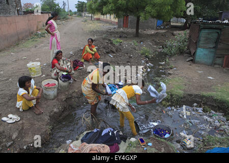 Solapur, Maharashtra, Indien. 20. Mai 2013. 20. Mai 2013: Solapur - Indien. In der Nähe von Solapur, Dorfbewohner sammeln Wasser aus einer über fließende Pipeline & Verwendung der unhygienisch Wasser zum Waschen ungefiltertes & trinken. Die wirtschaftlich schwachen Märkte in den städtischen Slums & Dörfern in Indien werden immer wichtiger für große multinationale Unternehmen wie sie zielen auf die Nachfrage nach frischem Wasser. Rund 96 Millionen Menschen in Indien haben keinen Zugang zu sauberem Wasser und mehr als 186.000 Kinder unter dem Alter von fünf sterben an Durchfall verursacht durch verschmutztes Wasser und mangelnde Hygiene wird jedes Jahr in das Land ein Stockfoto