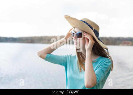 Sommersprossige Mädchen mit Hut, die durch die Brille des Sees geschaut Stockfoto