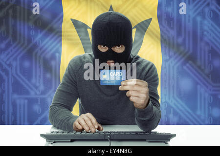 Dunkel-enthäutete Hacker mit Kreditkarte und Flagge auf Hintergrund - Barbados Stockfoto