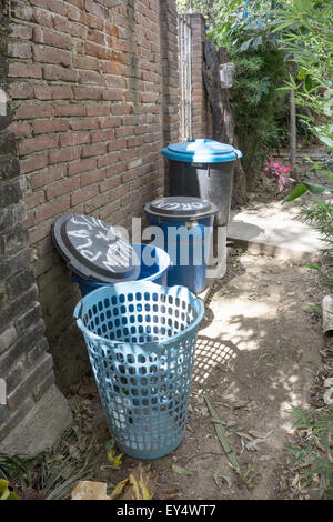 verschiedene Größe blau gekennzeichnete recycling Plastikwannen fein säuberlich aufgereiht entlang einer alten Mauer in einem malerischen Garten Oaxaca zu leeren Stockfoto