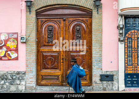 Ein Alter Mann in traditioneller Kleidung der Anden-Region geht auf der Straße. Otavalo, Ecuador. Stockfoto