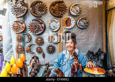 Ein Mann verkauft Holz geschnitzt Artefakte am lokalen Markt. Otavalo, Ecuador. Stockfoto