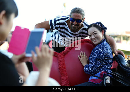 Venedig, Italien. 21. Juli 2015. Wu Juan (R), ein Lastkahn-Frau aus Zhouzhuang, posiert für Fotos mit einem Gondoliere in Venedig, Italien, 21. Juli 2015. Während der Expo Mailand 2015 hält Chinas Zhouzhuang ein Seminar in Mailand und eine Veranstaltung namens "A Tale of Two Cities" in Venedig um die chinesische Kultur der "Wasserstadt" einzuführen. © Jin Yu/Xinhua/Alamy Live-Nachrichten Stockfoto