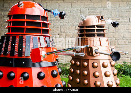 Zwei Daleks aus der BBC-TV-Serie. Eine rote Markierung drei Dalek neben einer neuen Serie Dalek Design in Metallic Bronze Farbschema. Im Freien Stockfoto