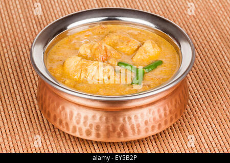 Indische Hühnchen-Curry in authentischen Kupfer Schüssel serviert. Grüne Chili als Garnitur verwendet. Stockfoto