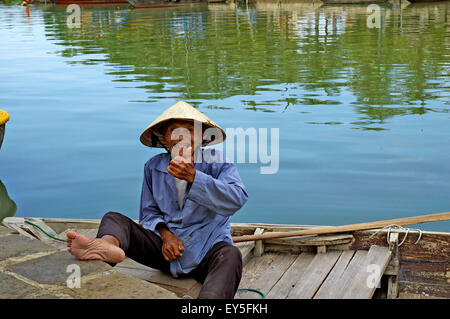 Einen älteren vietnamesischen Mann, mit einem traditionellen konischen Hut lächelnd und geben einen Daumen nach oben Zeichen von einem Boot in Hoi an ein. Stockfoto