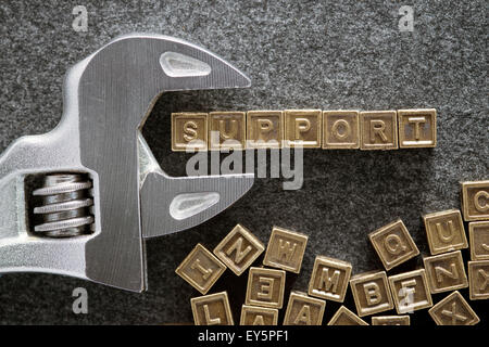Wort, das aus verschiedenen metallischen Blöcke mit verstellbaren Schraubenschlüssel an Tafel zu unterstützen Stockfoto