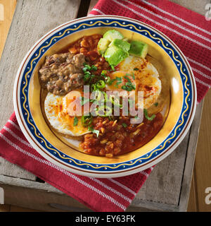 Huevos Rancheros. Spiegeleier auf Tortillas mit Tomaten-Chili-Soße und gebackenen Bohnen Stockfoto