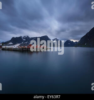 Rotes Rorbu Fischerhütten über Fjord, Hamnøy, Reine, Moskenesøy, Lofoten Inseln, Norwegen Stockfoto