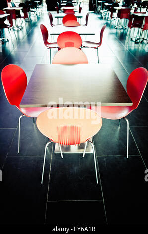 roten Kunststoff-Stühle und Tische in einem modernen Fast Foodrestaurant Stockfoto