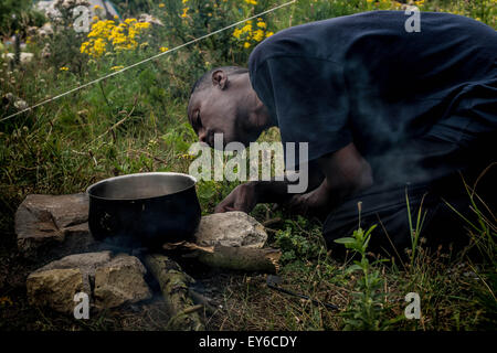 Calais, Frankreich. 22. Juli 2015. Idris, 25 aus Erythrea Vorbereitung das Feuer legen, um seine Mittagessen kochen (Credit-Bild: © Velar Grant über ZUMA Draht) Credit: ZUMA Press, Inc./Alamy Live News Stockfoto