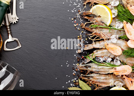 Frische Garnelen mit Gewürzen und Weißwein auf schwarzem Stein. Draufsicht mit Textfreiraum Stockfoto