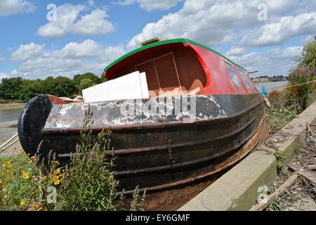 Eine verlassene schmale Boot liegt gebunden in kleinen Gewinn Dock, Barnes, London Stockfoto