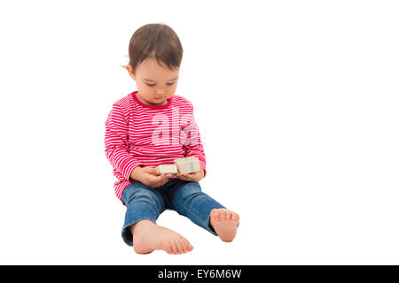 Kleine süße Mädchen öffnen eine Geschenk-Box, auf dem weißen Hintergrund isoliert Stockfoto