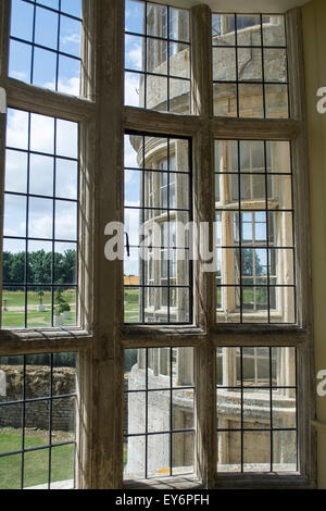 Blick durch eine verglaste Bogen Fenster aus einem Schlafgemach in Kirby Hall, Northamptonshire NN17 3EN Stockfoto