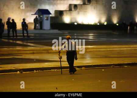 Athen, Griechenland. 22. Juli 2015. Ein Alter Mann geht auf dem Syntagma-Platz mit der Bereitschaftspolizei, die gerade im Hintergrund. Griechen protestierten vor dem griechischen Parlament als 2. Tranche der neuen Sparmaßnahmen wurden im Parlament diskutiert. Die neuen Gesetze sind ein Gesetz und Banking-Reform. Der Protest blieb weitgehend friedlich mit ein paar Schlägereien zwischen Polizei und Anarchisten am Ende. Bildnachweis: Michael Debets/Alamy Live-Nachrichten Stockfoto