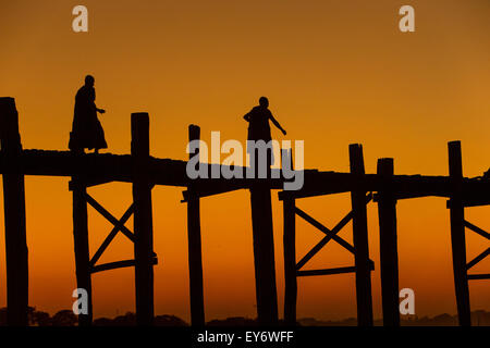 Mönche, die Kreuzung U-Bein Teak Fußgängerbrücke bei Sonnenuntergang, Myanmar Stockfoto