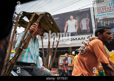 Werbetafel und Leben auf der Straße in Varanasi, Indien. Stockfoto