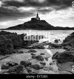 Leuchtturm-Landschaft mit Gewitterhimmel über Meer in schwarz / weiß Stockfoto