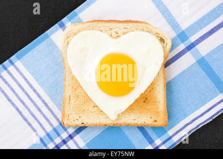 Sonnenseite, Ei in Herzform auf Toast, Ansicht von oben. Ich liebe das Frühstück. Frische, moderne Bildsprache. Kochkunst. Stockfoto