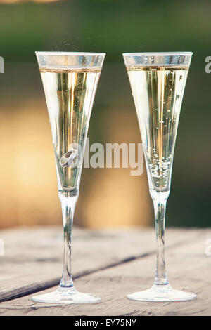 Goldringe in ein Glas mit Champagner Stockfoto